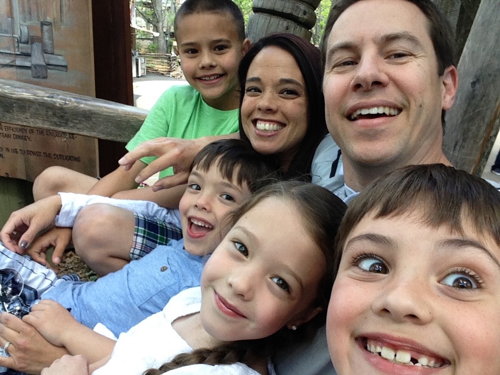 The whole family in the big wooden chair at Silver Dollar City.